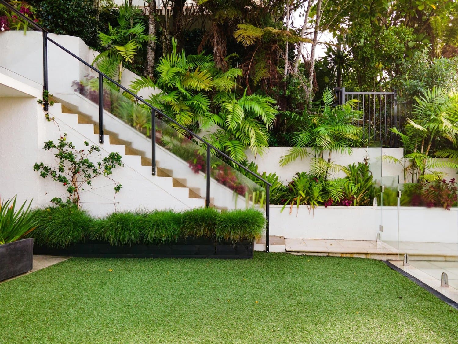 Lush lawn below a terraced garden with stairs