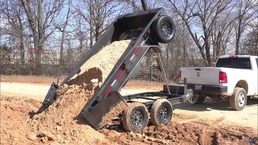 Dump trailer unloading soil on a job site